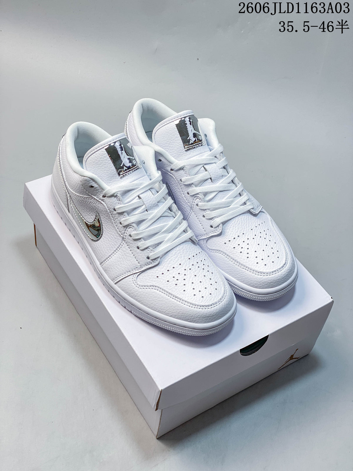 Pair of white Jordan Air Jordan 1 SE low-top sneakers shown from above, with reflective silver-tone details.