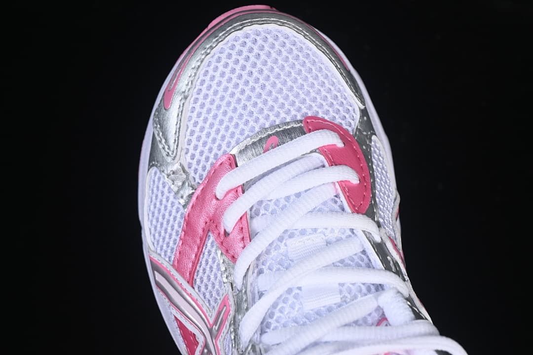 Top view of the sneaker toe, laces, and silver and pink accents.