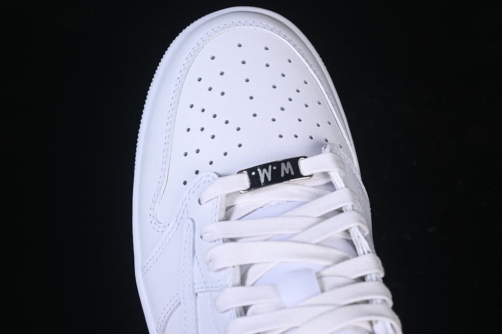 Top-down close-up of perforated toe, white laces, and lace tag