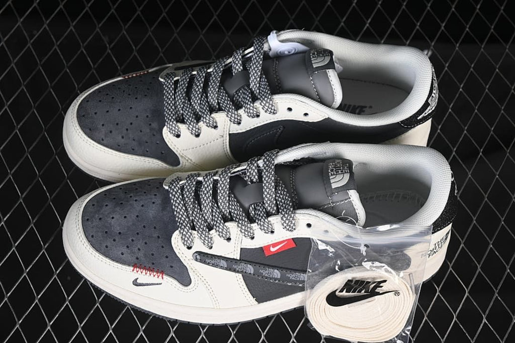 Pair of dark gray and off-white low-top sneakers with patterned laces and an extra lace set.
