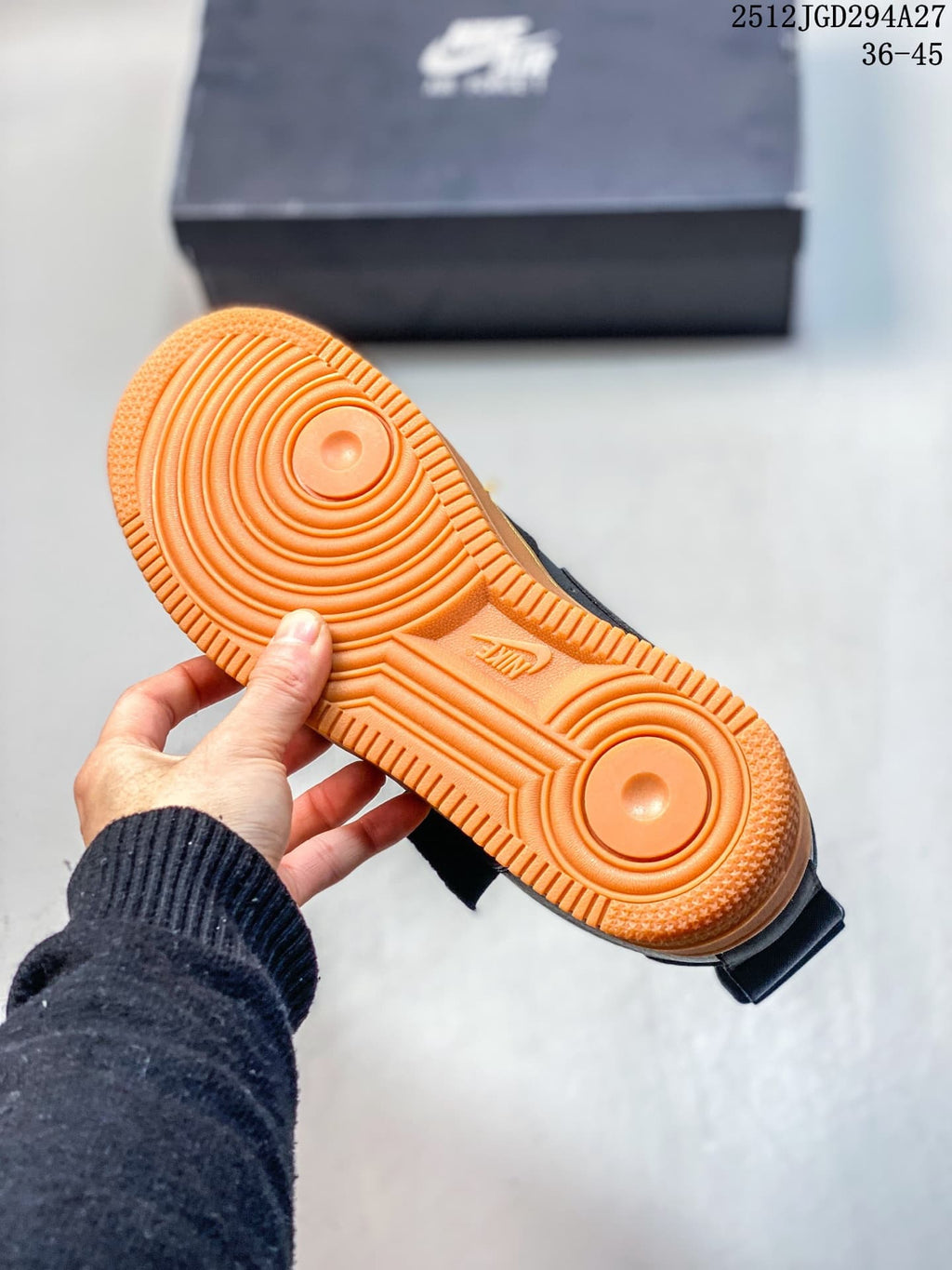 Close-up of the orange circular-pattern outsole on a black sneaker