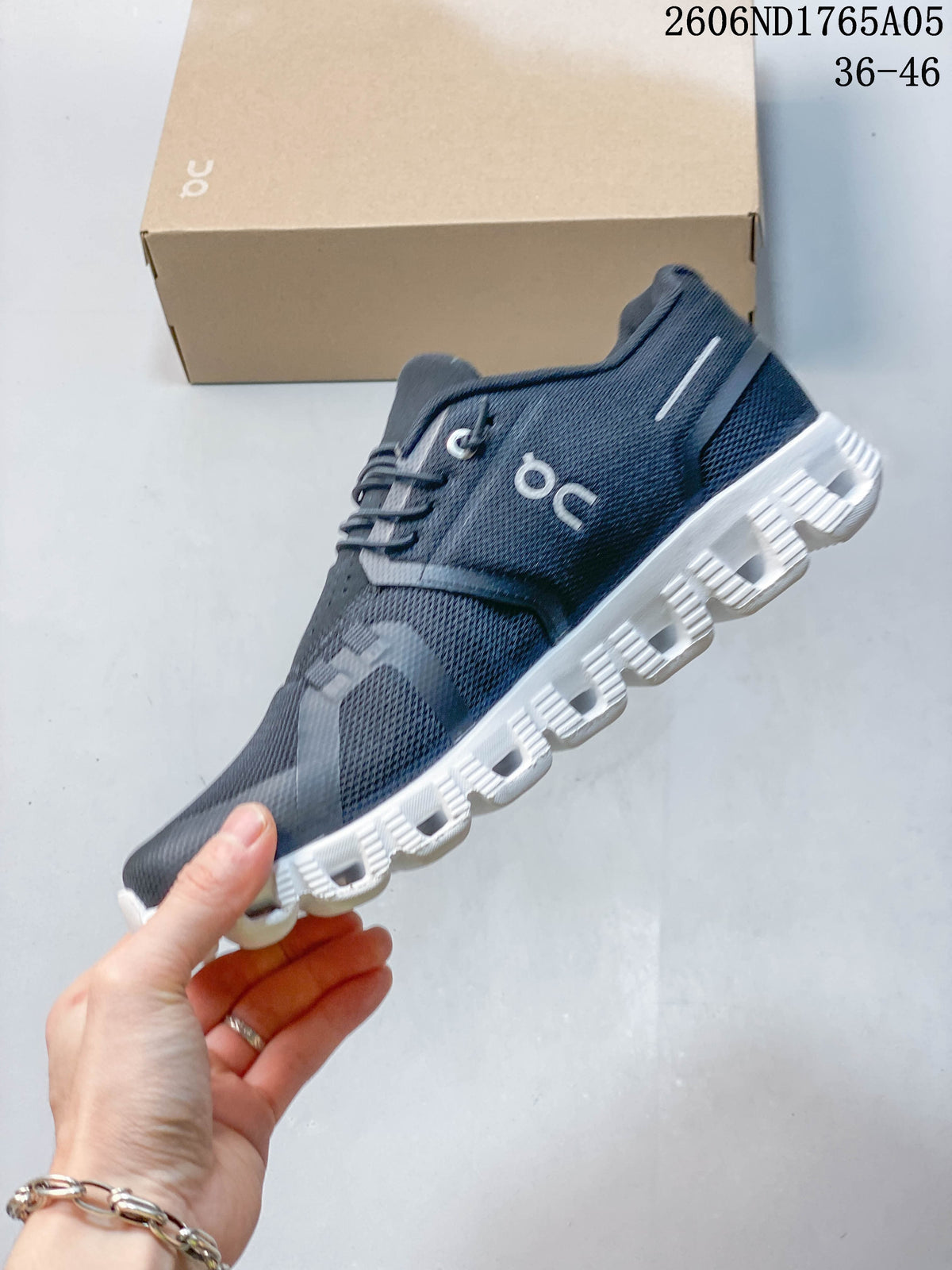 Side view of a charcoal On Cloud 5 sneaker showing its mesh-look upper and speed lacing