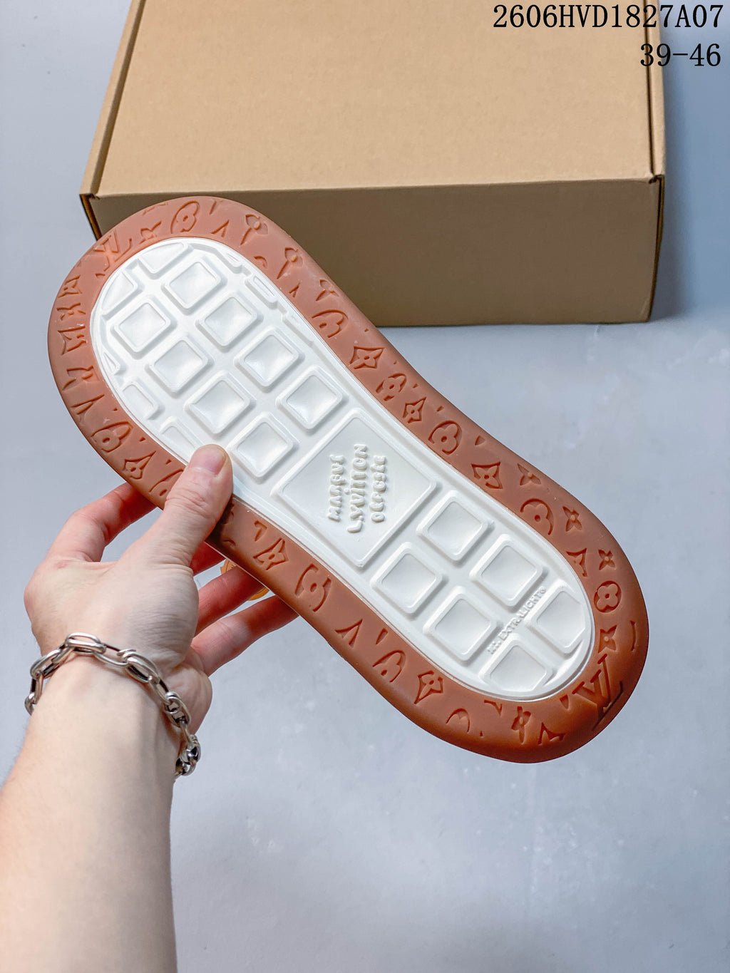 Underside of the sneaker showing a white patterned center and gum-brown outer sole.