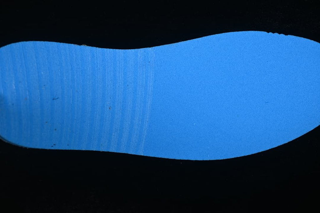 Blue outsole detail photographed against a dark background