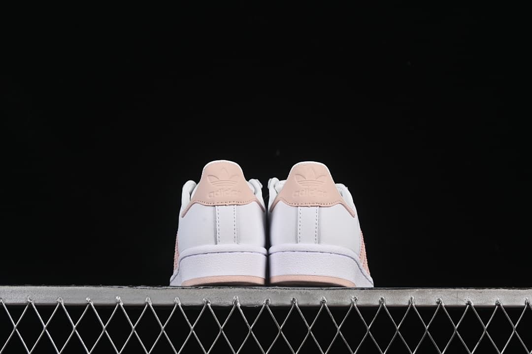 Rear view of both sneakers with blush-pink heel tabs.