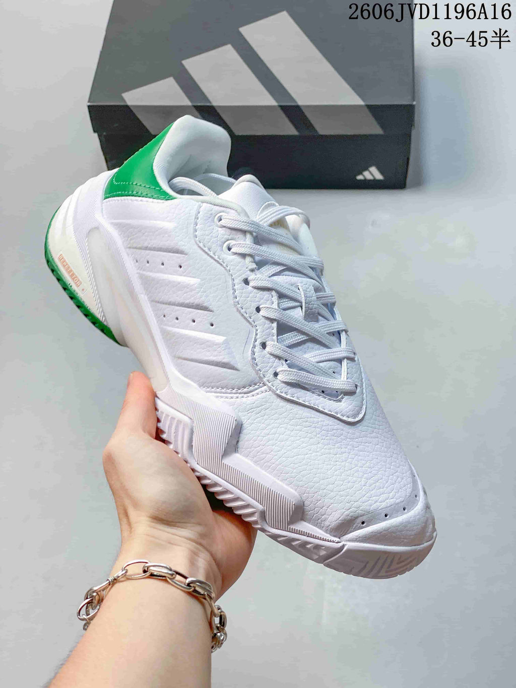Angled side view showing the textured white upper and green heel panel.
