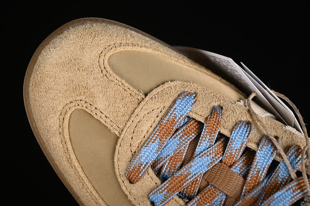 Top detail of suede-look toe overlay and blue-and-brown patterned laces