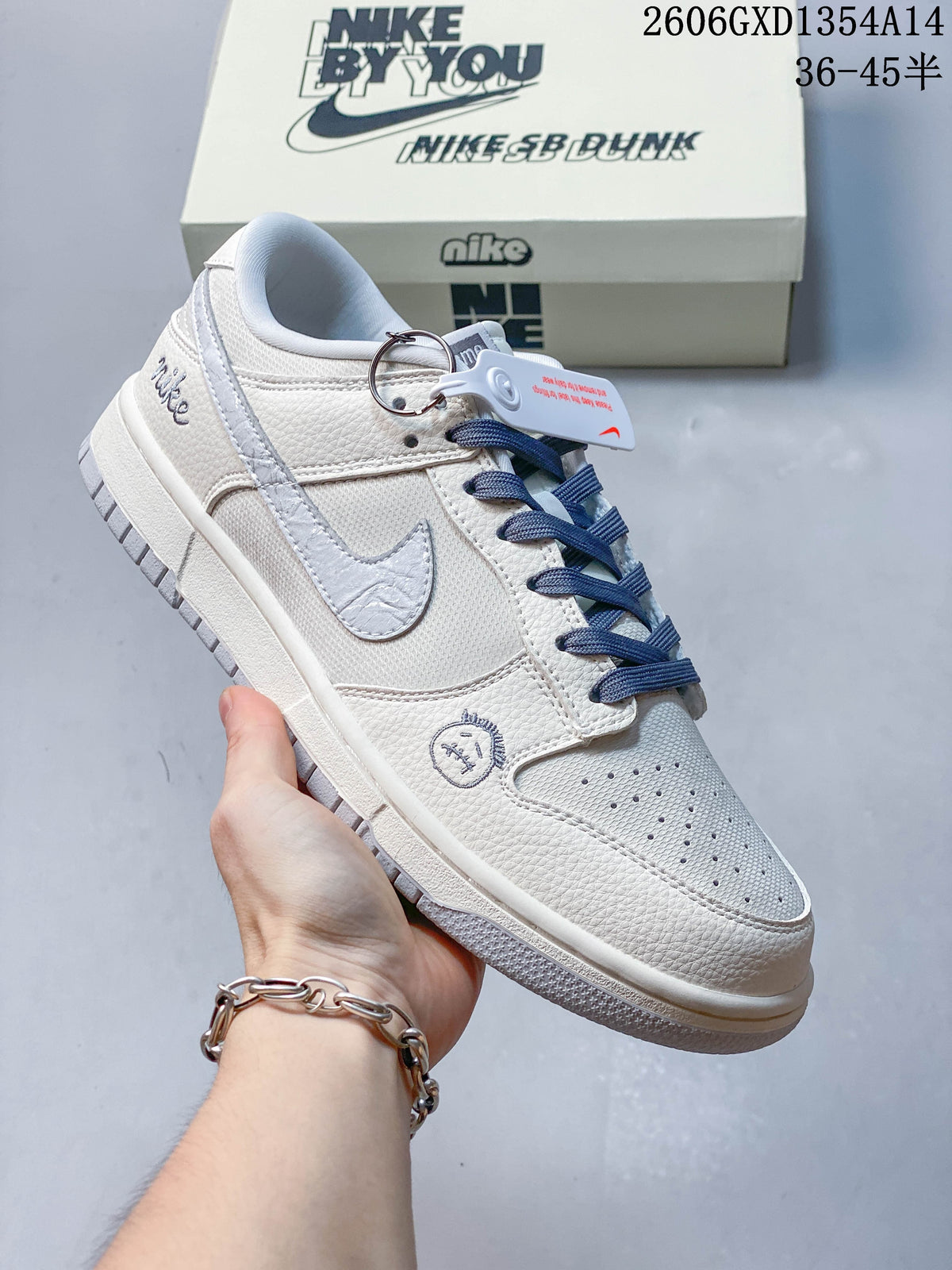 Side view of an off-white Nike Dunk Low sneaker with navy laces and embroidered details