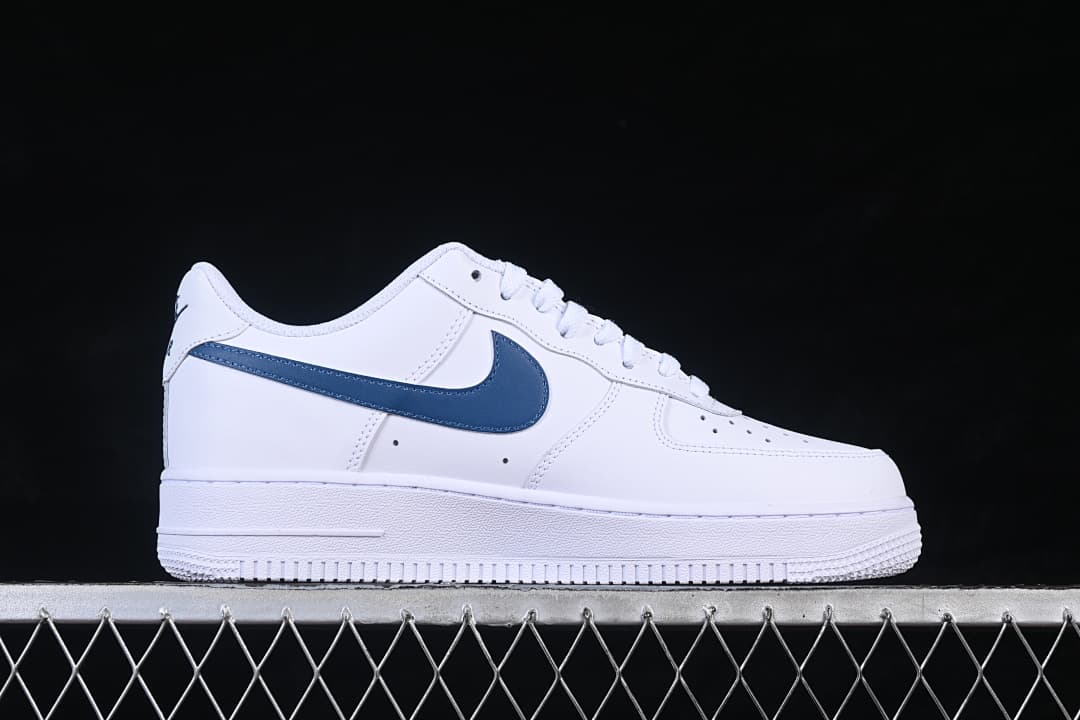 Side view of a white Nike Air Force 1 ’07 Low sneaker with a navy-blue Swoosh