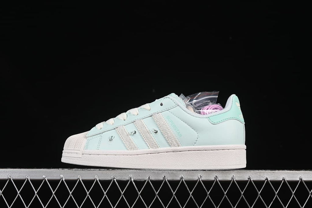Side profile of the mint green sneaker against a dark background