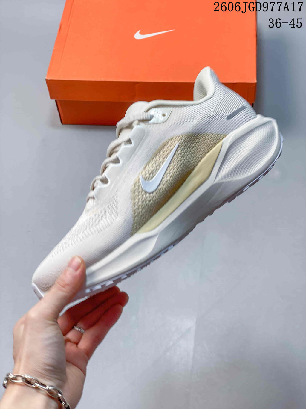 Side profile of an off-white Nike Air Zoom Pegasus 41 shoe with pale gold accents.