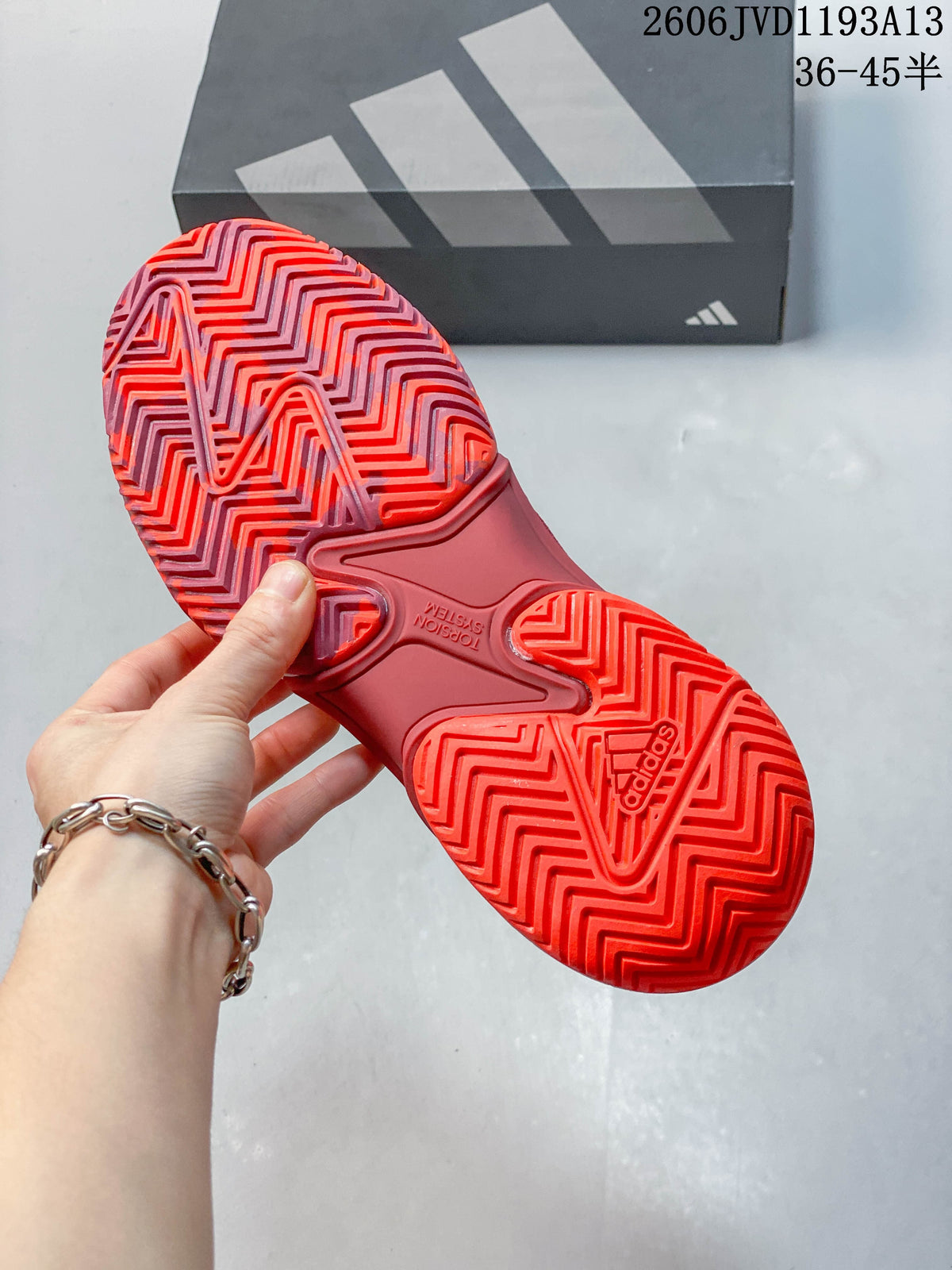 Close-up of the red tennis shoe outsole with a patterned tread.