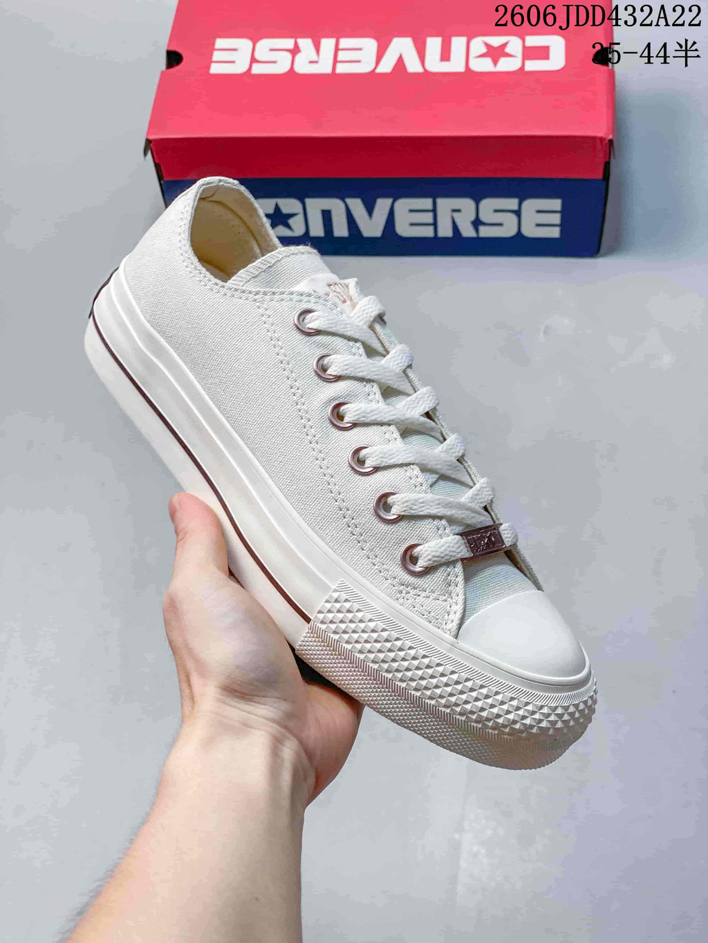 Close view of an off-white low-top sneaker with metal eyelets and a textured white toe bumper