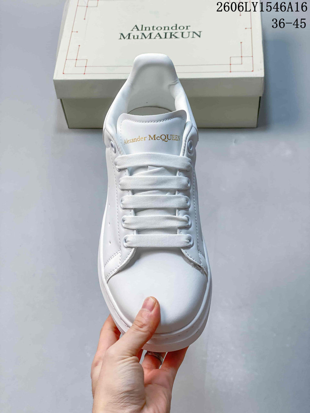 Front view of a white lace-up sneaker with branding on the tongue.