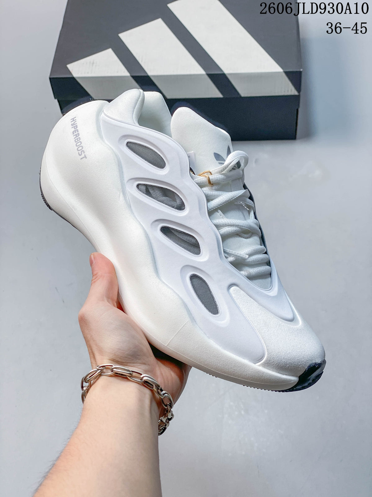 Angled side view of the white adidas Hyperboost sneaker with gray details and dark outsole accents.