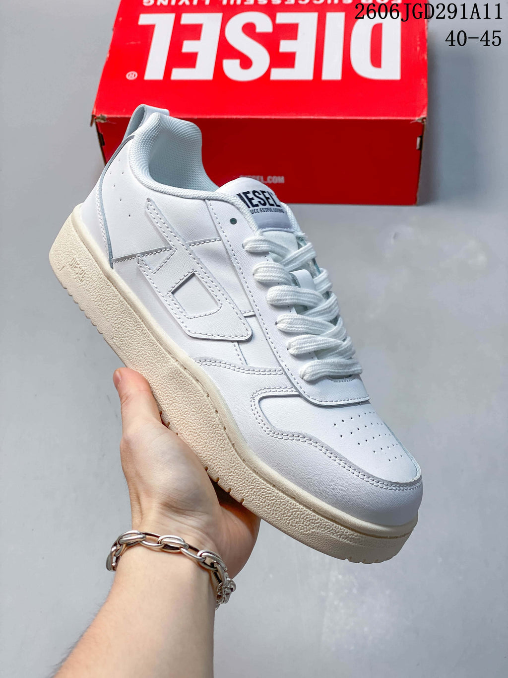 Angled side view of the white sneaker with its logo detail and textured sole.