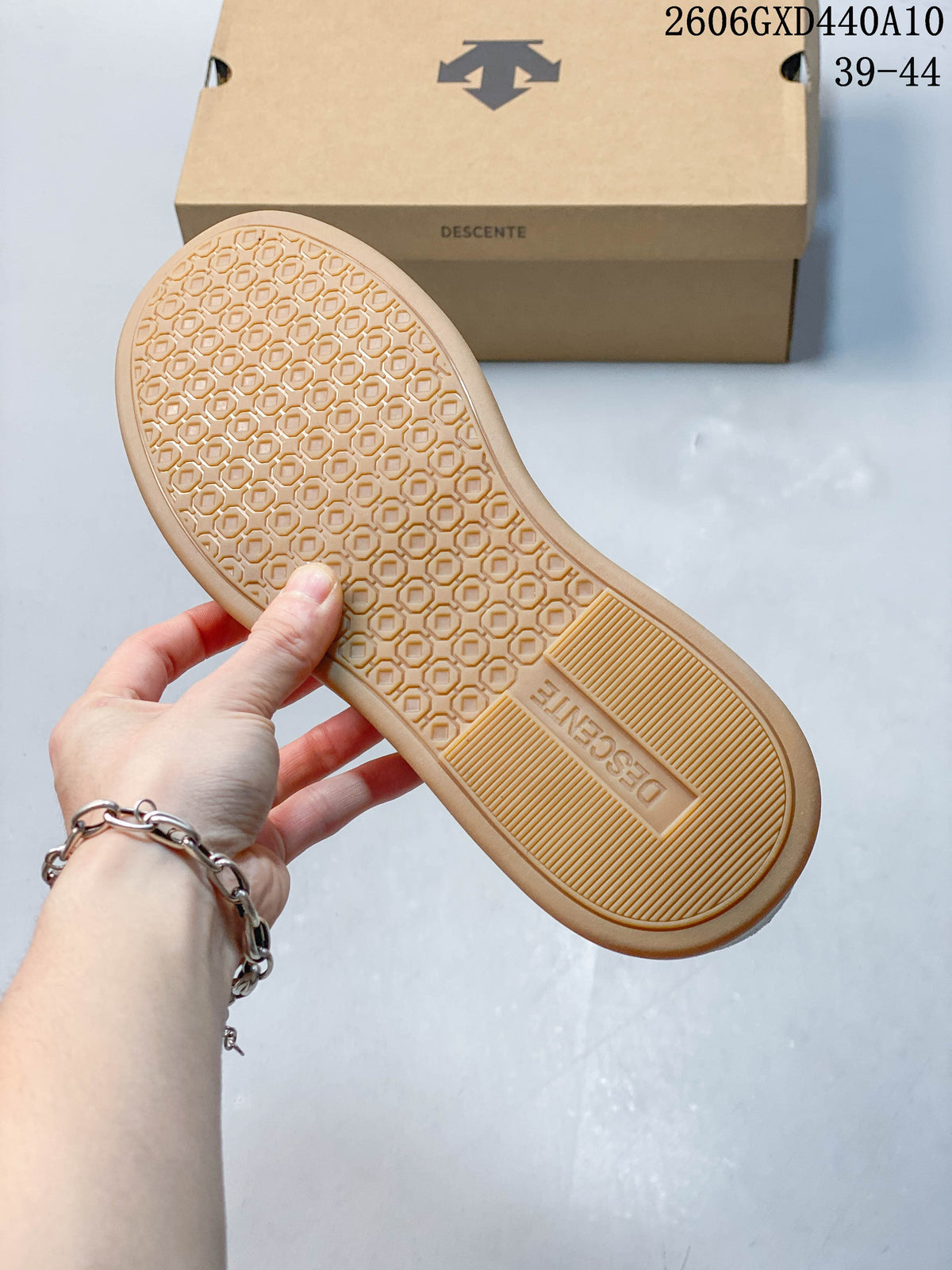 Close-up of the gum-colored outsole with a repeating geometric tread pattern.