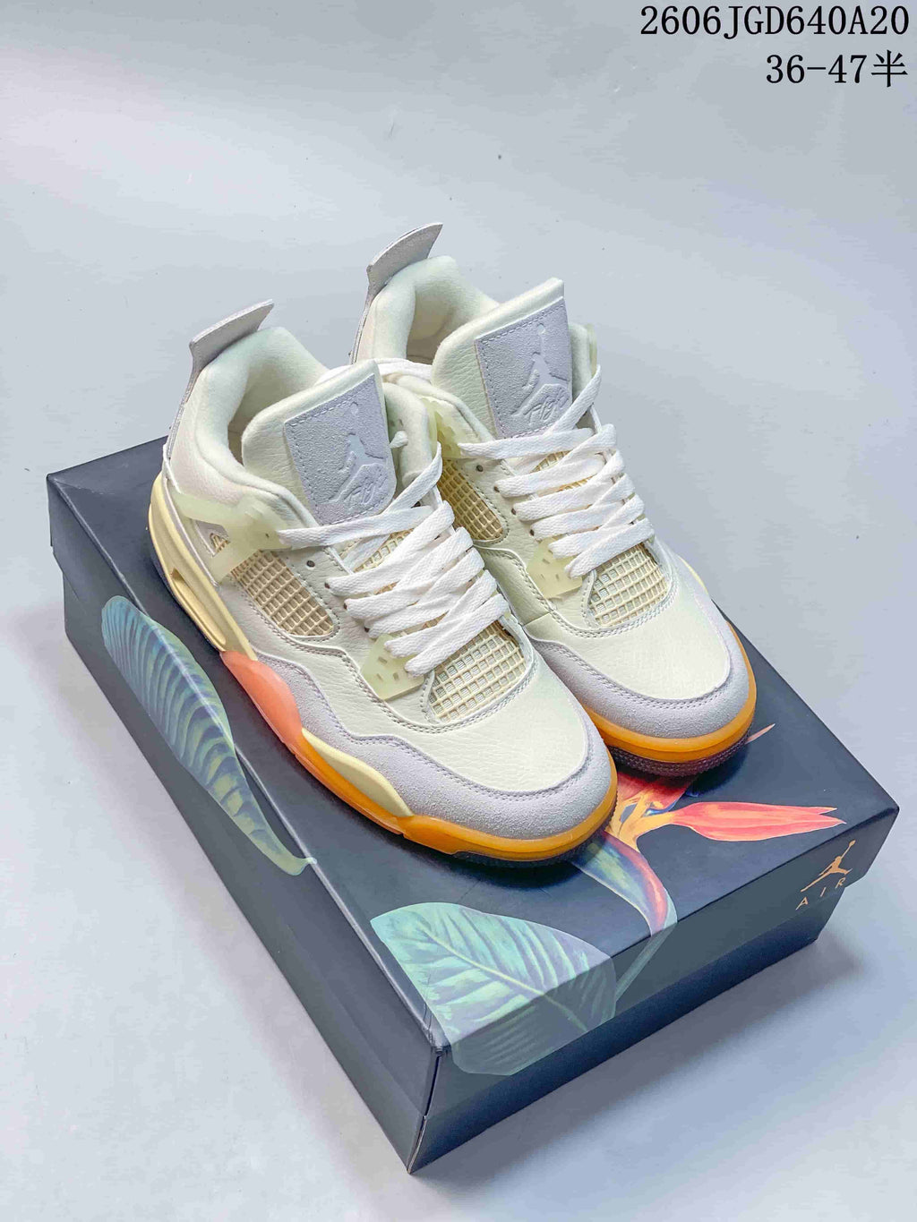 Pair of beige and gray Jordan Air Jordan 4 Birds of Paradise sneakers on a floral graphic shoebox