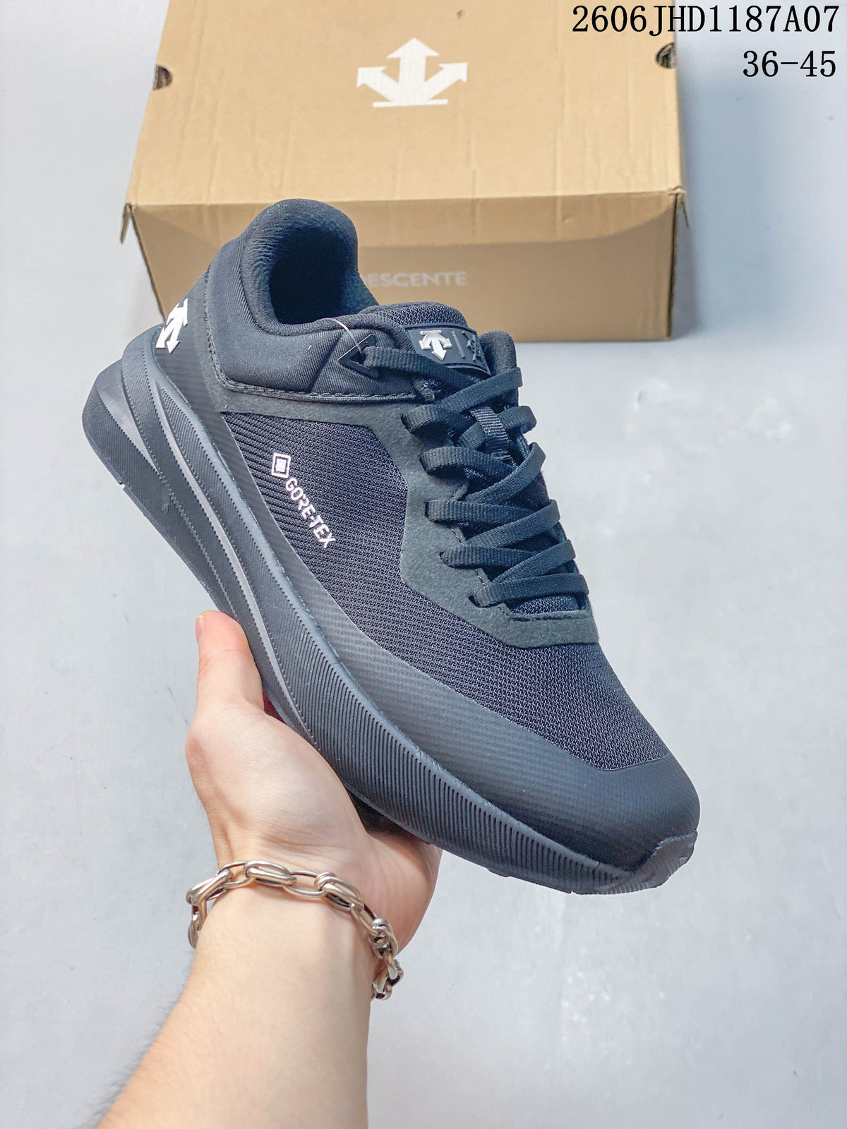 Angled side view of a dark charcoal Descente sneaker with mesh-look panels