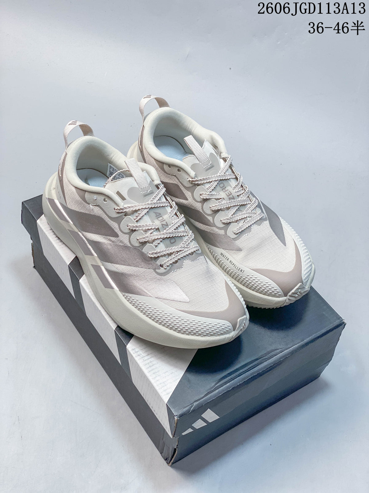 Pair of light grey and off-white Adidas Adizero Pro Evo SL ATR shoes displayed on a shoebox
