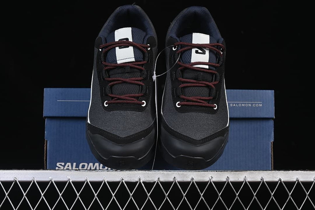 Front view of the pair of black and white shoes on the box.