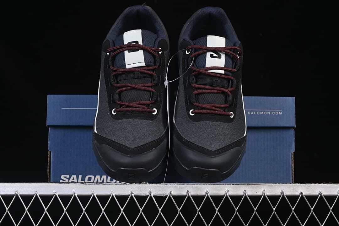 Front view of the pair of black and white shoes on the box.