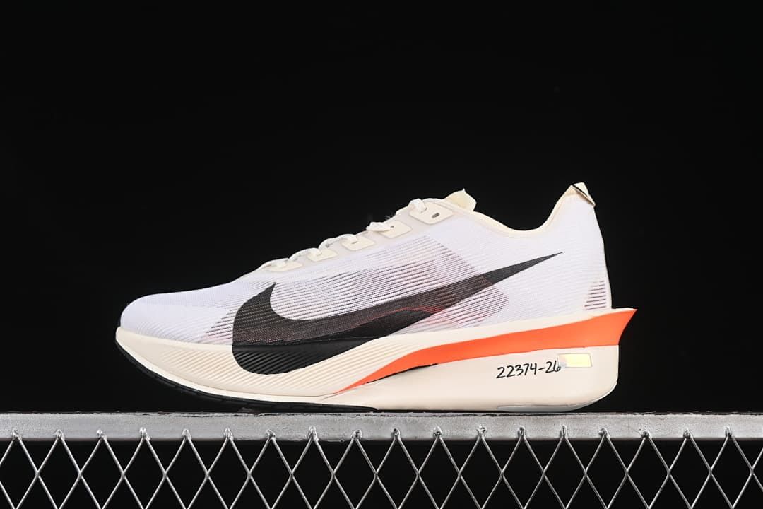 Side view of the white shoe with black Swoosh and orange midsole accent