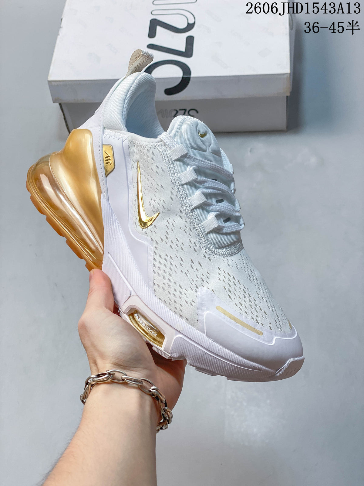 Angled side view of a white Nike Air Max 270 sneaker with amber-colored heel unit