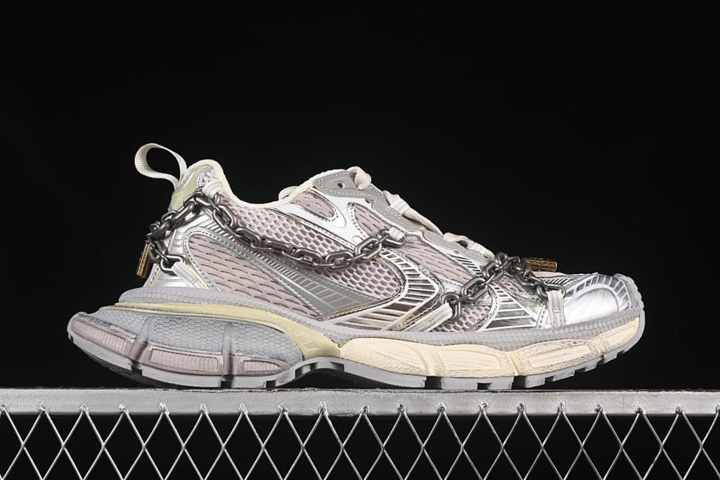 Side profile showing the layered panels, chain, and chunky sole.