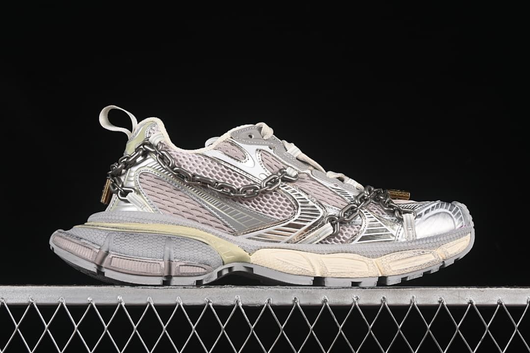 Side profile showing the layered panels, chain, and chunky sole.