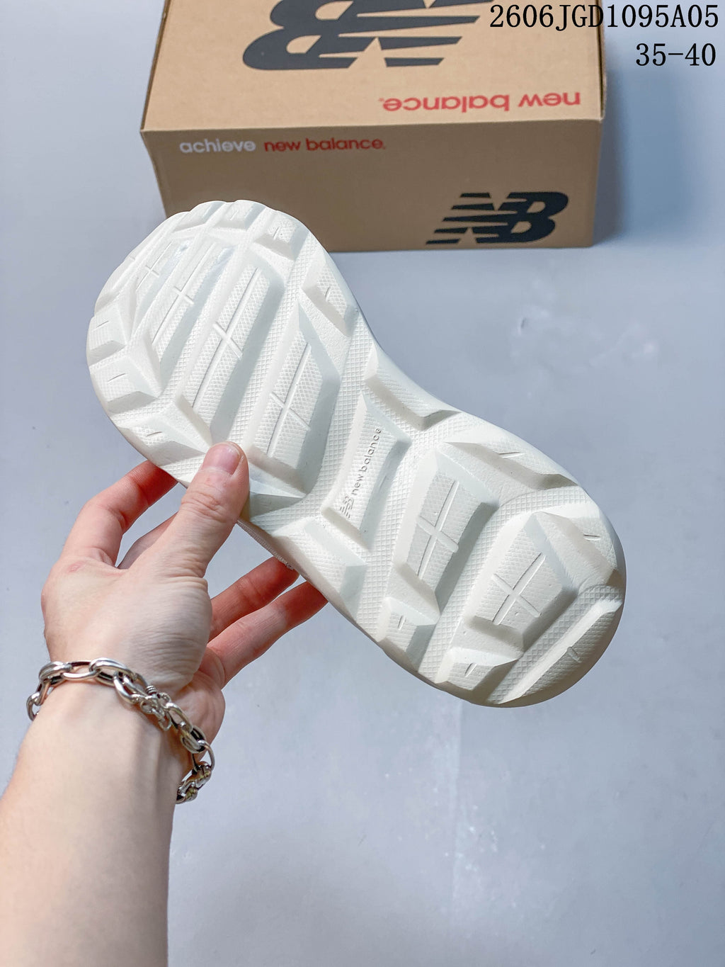 Outsole view of a white New Balance Breeze sneaker with a sculpted tread pattern