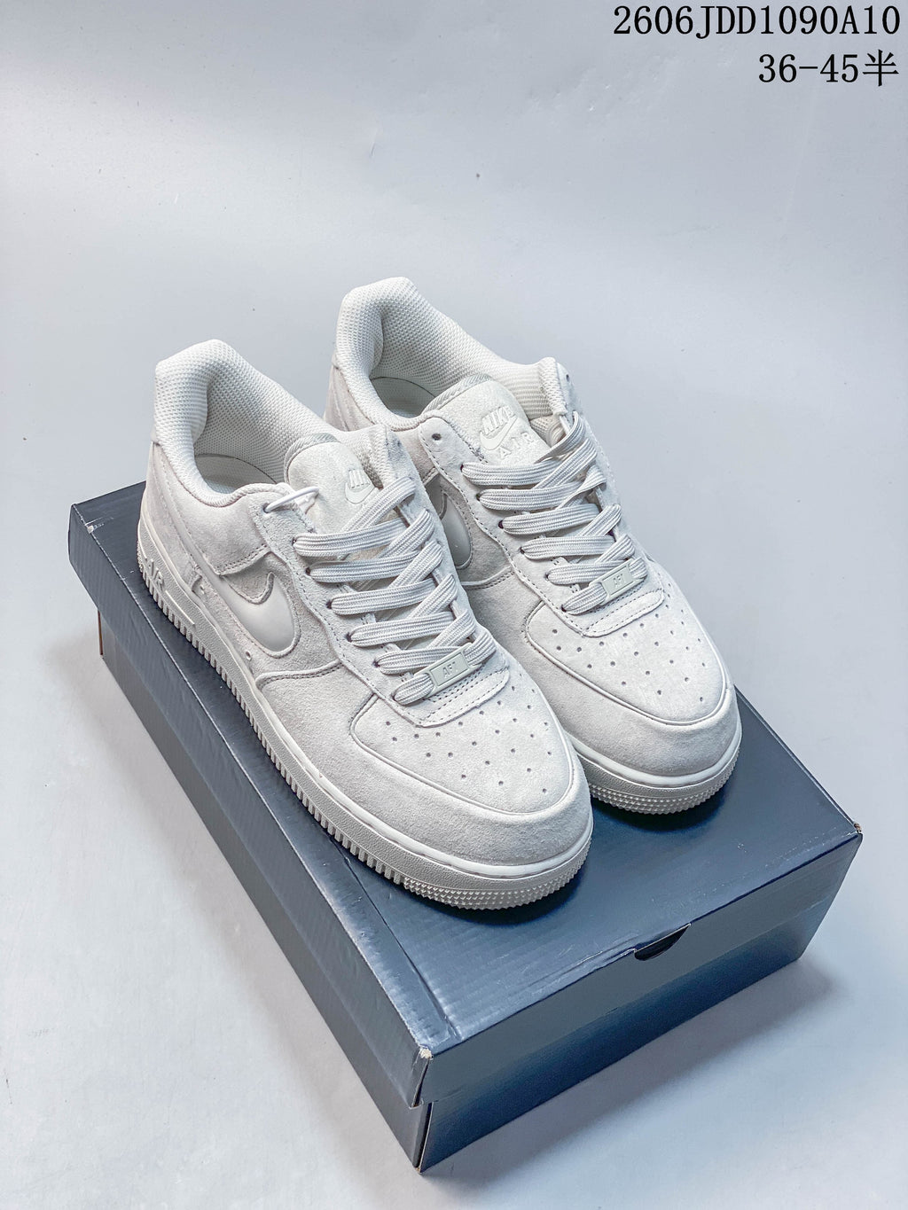 Pair of white Nike Air Force 1 low-top sneakers with tonal details.