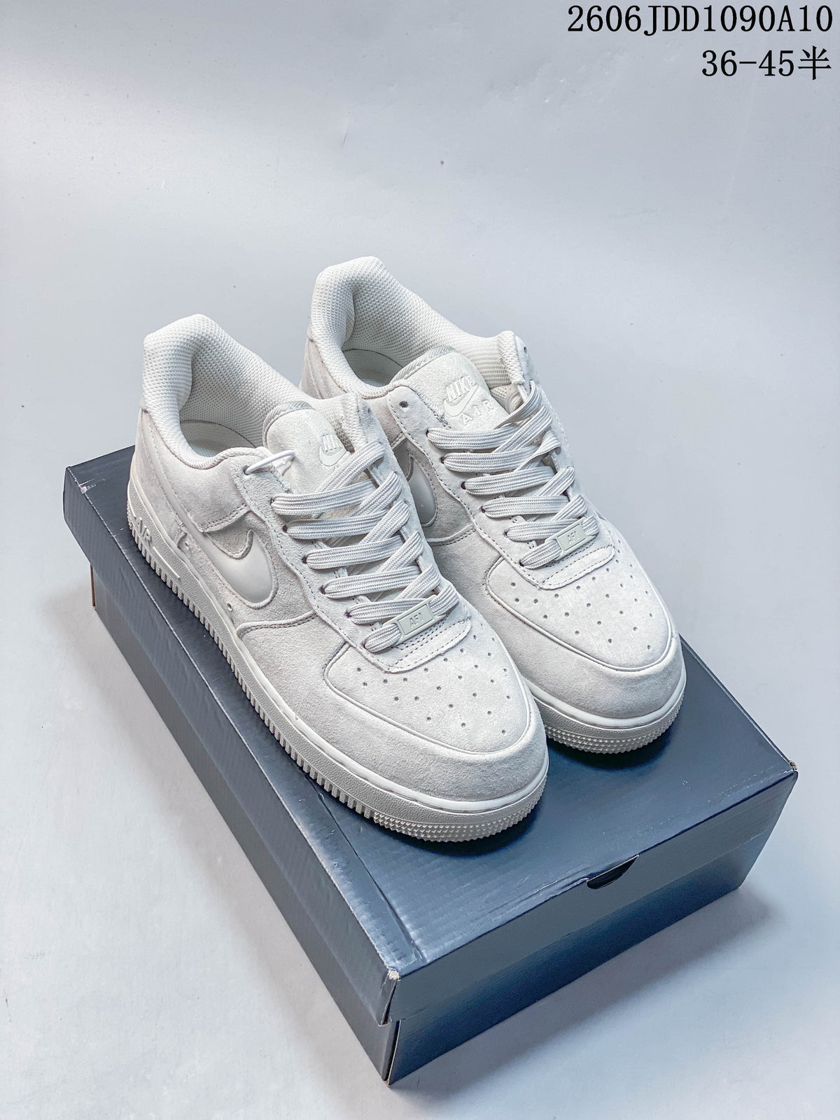 Pair of white Nike Air Force 1 low-top sneakers with tonal details.