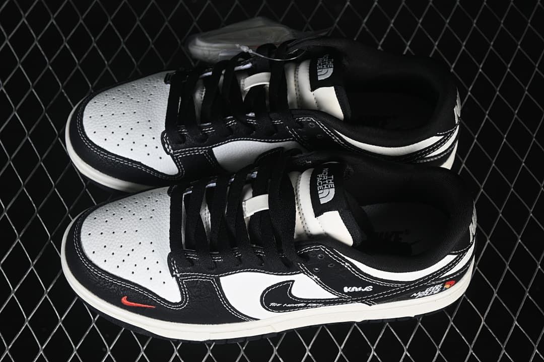 Top view of a pair of black and white low-top sneakers showing perforated toe panels and black laces