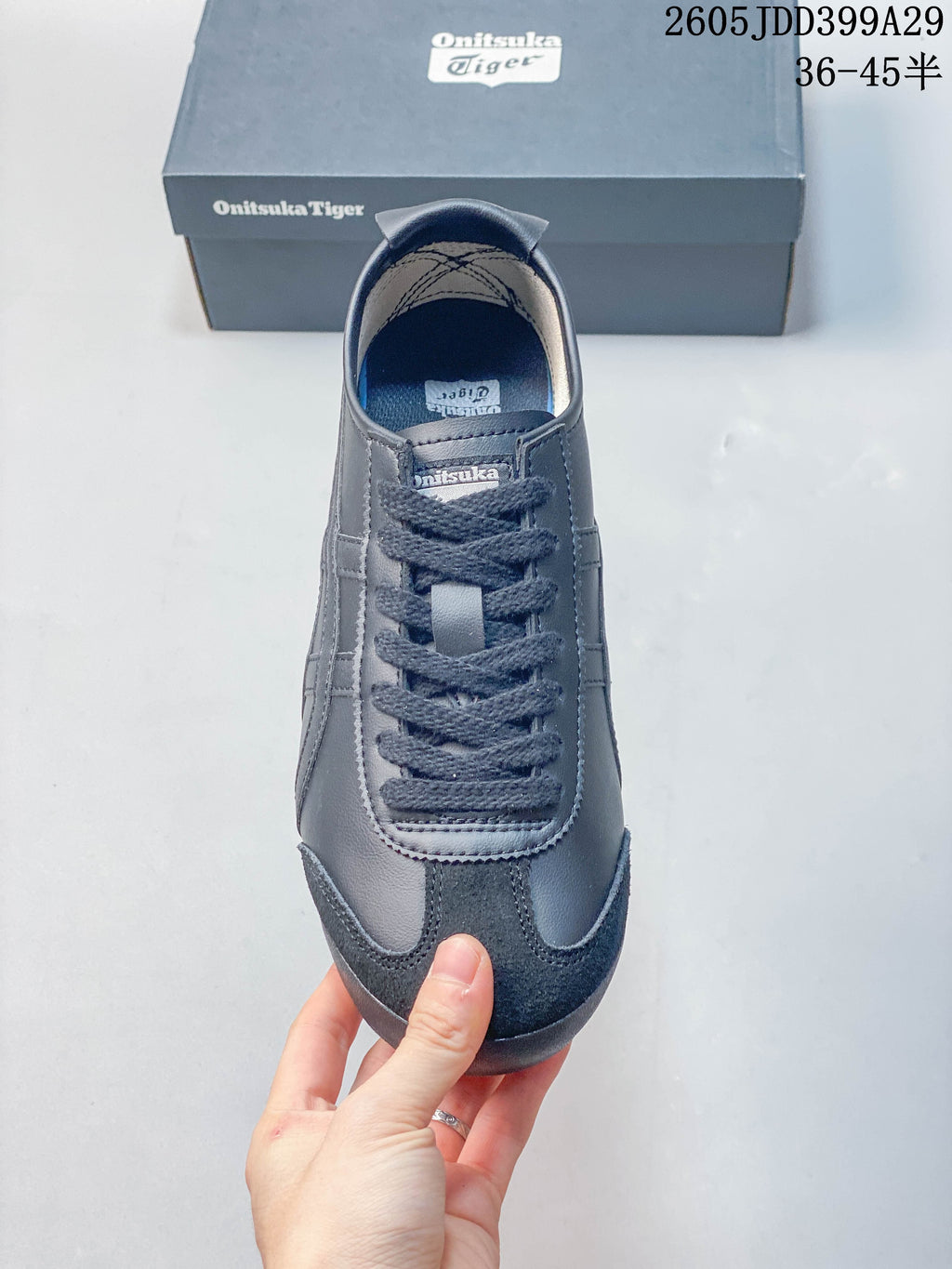 Top view of a gray Onitsuka Tiger lace-up sneaker showing the tongue, laces and toe overlay.