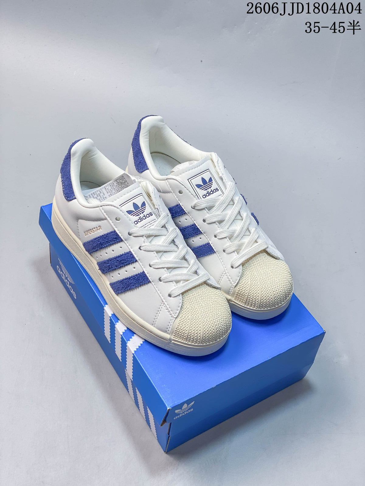 Pair of white Adidas Originals Campus 00s sneakers with blue stripes and cream-toned shell toes