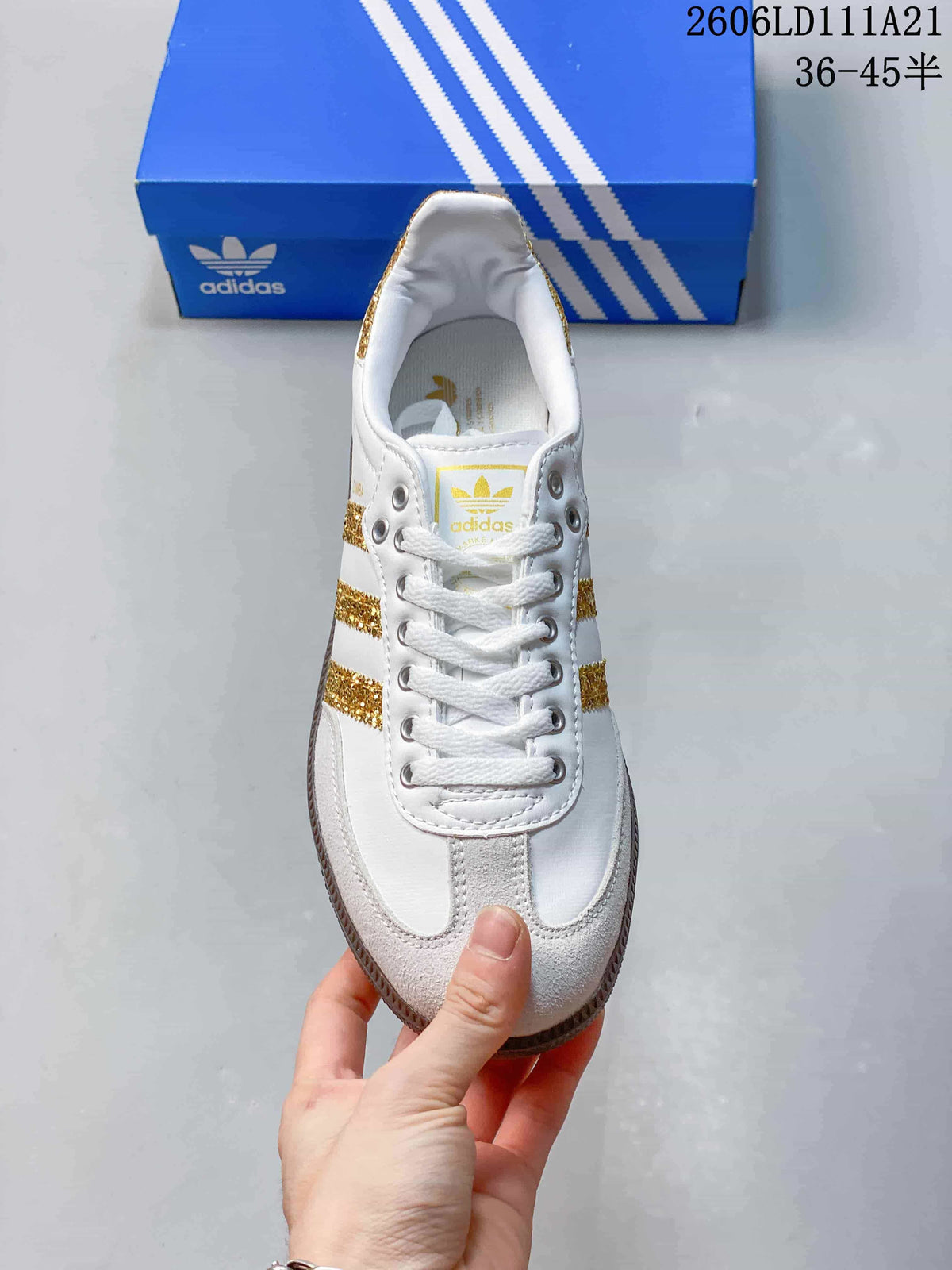 Top view showing white laces, gold-striped sides, and the light-colored toe overlay.