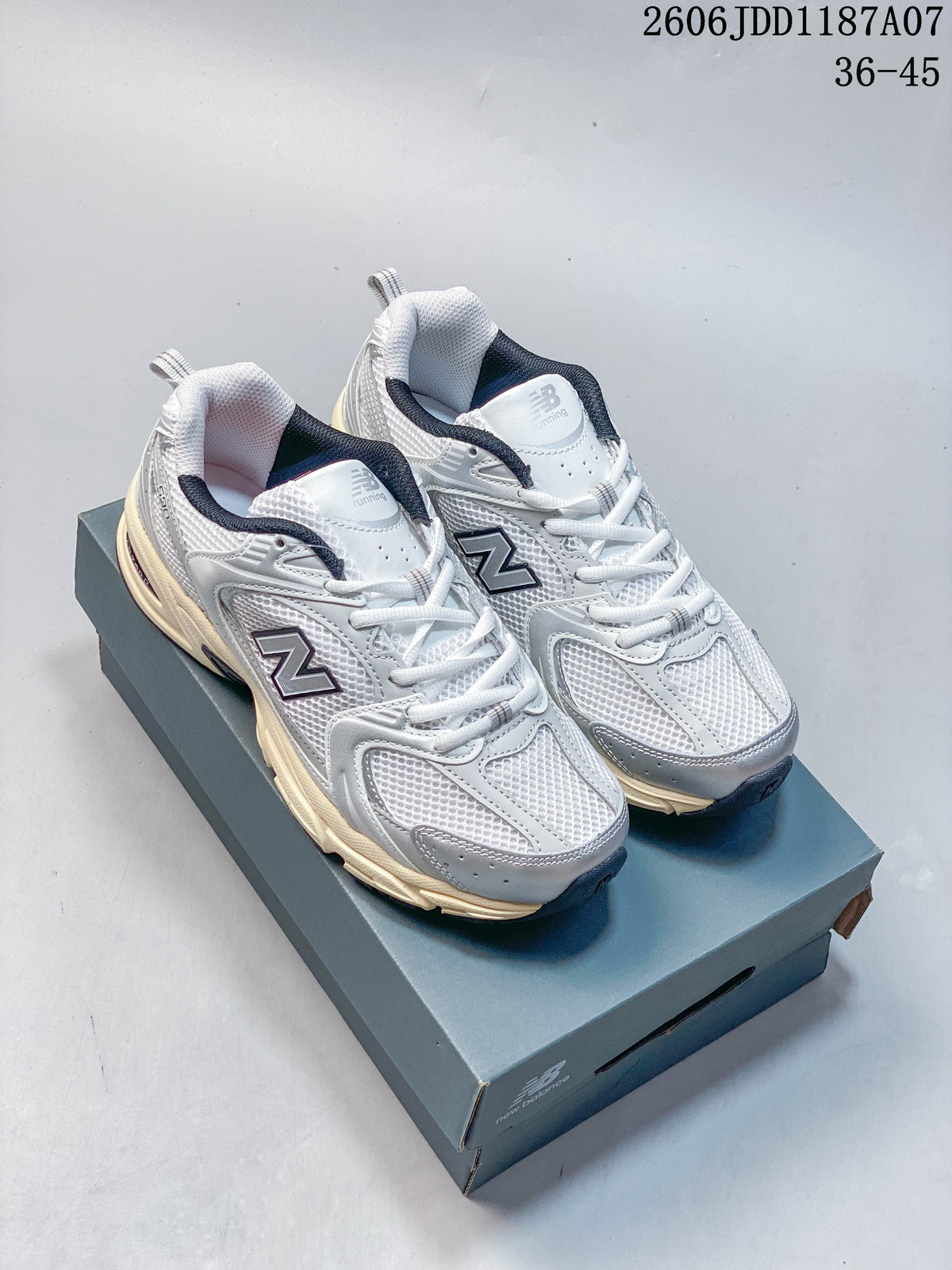 Pair of white and grey New Balance 530 sneakers shown from above on a shoe box