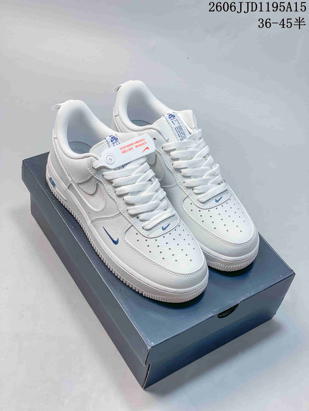 Pair of white low-top sneakers with small blue Swoosh accents and perforated toe panels.