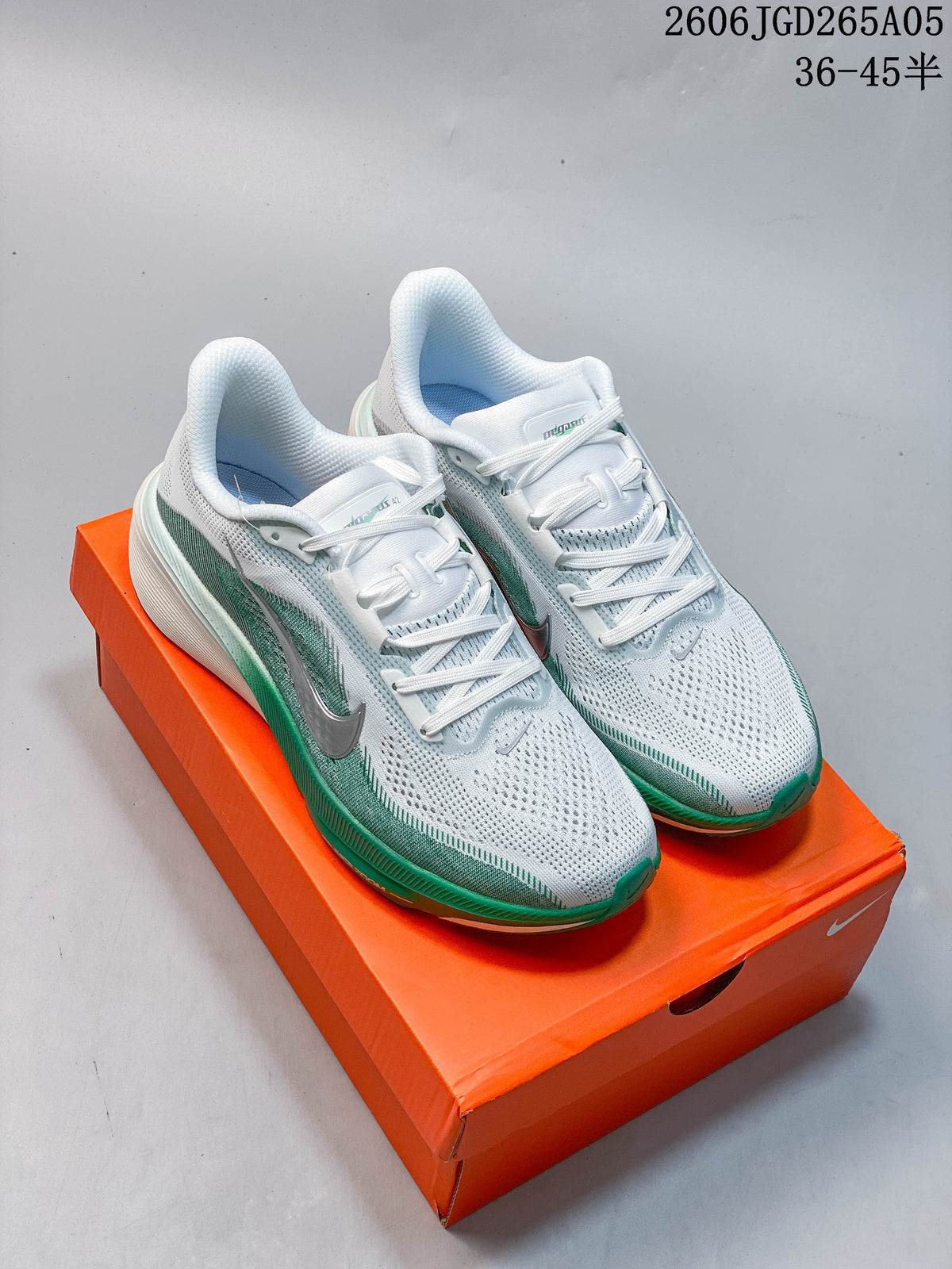 Pair of white and green Nike Pegasus 42 running shoes on an orange box
