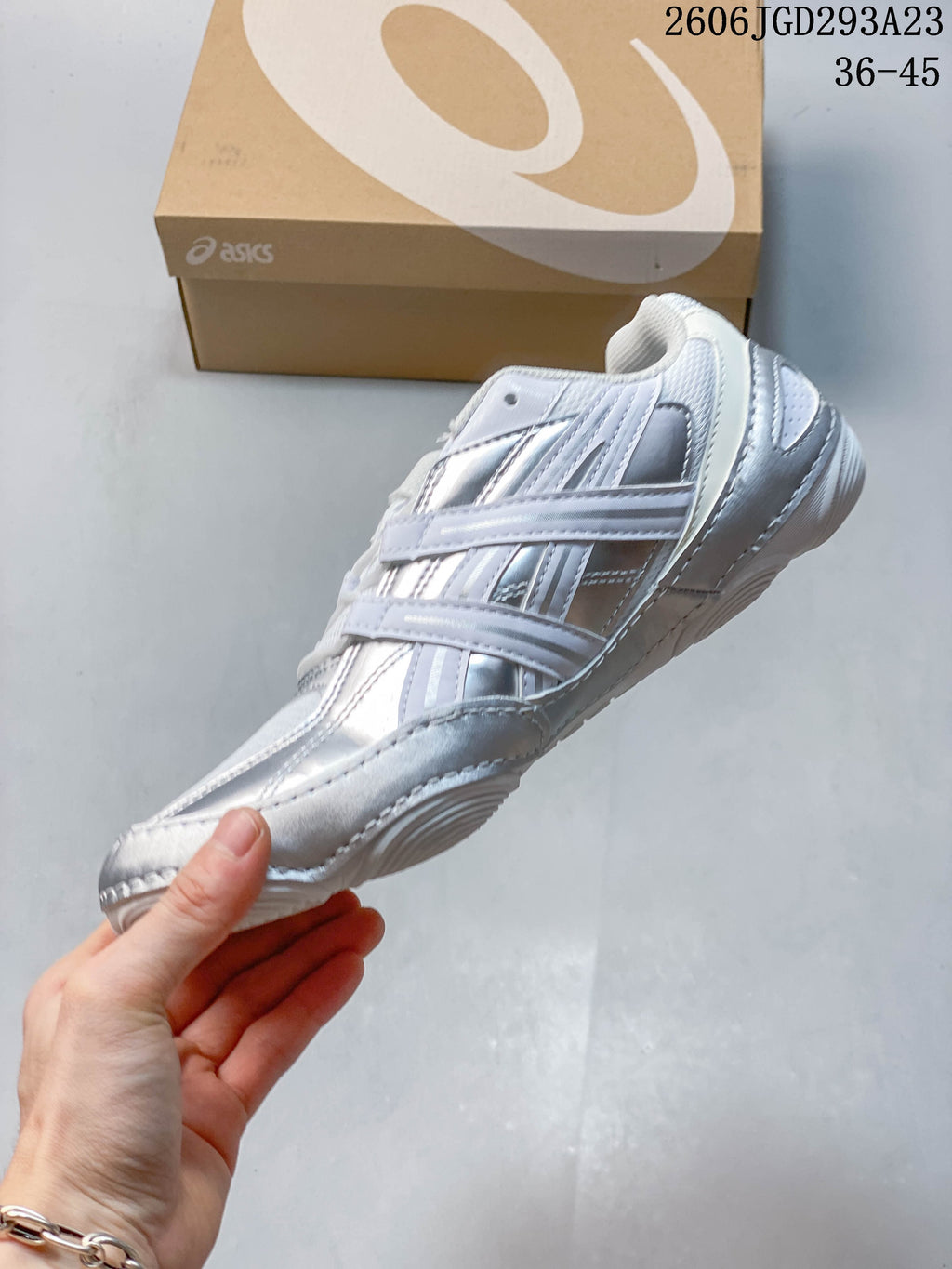 Side view of the white and silver lace-up sneaker.