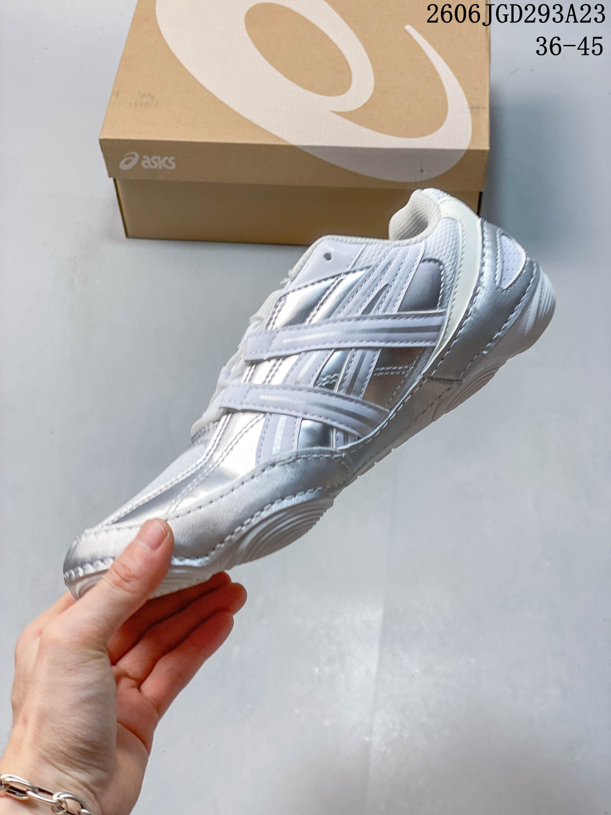 Side view of the white and silver lace-up sneaker.