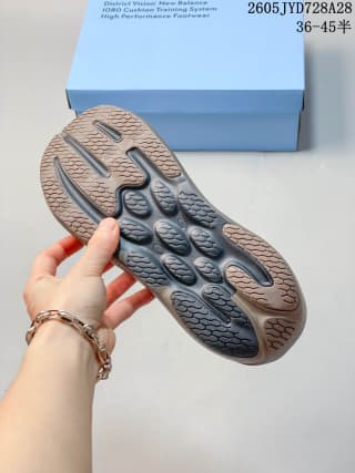 Underside view showing the patterned outsole of a taupe-brown running shoe