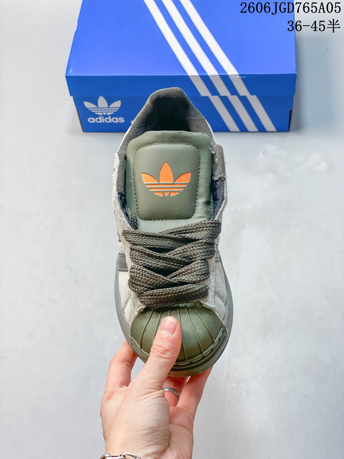 Top view of an Adidas Originals Superstar XLG sneaker showing its shell toe, laces, and orange trefoil detail
