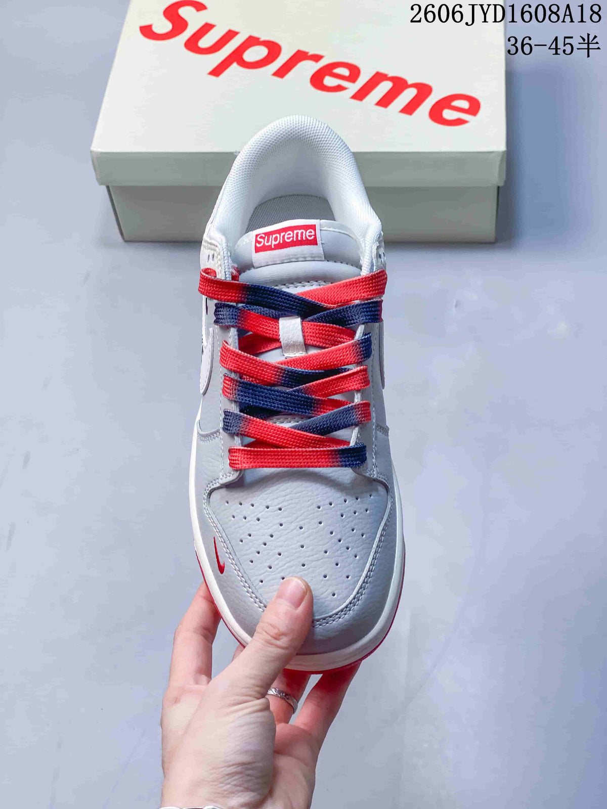 Top view showing perforated toe panels and alternating red and navy laces.