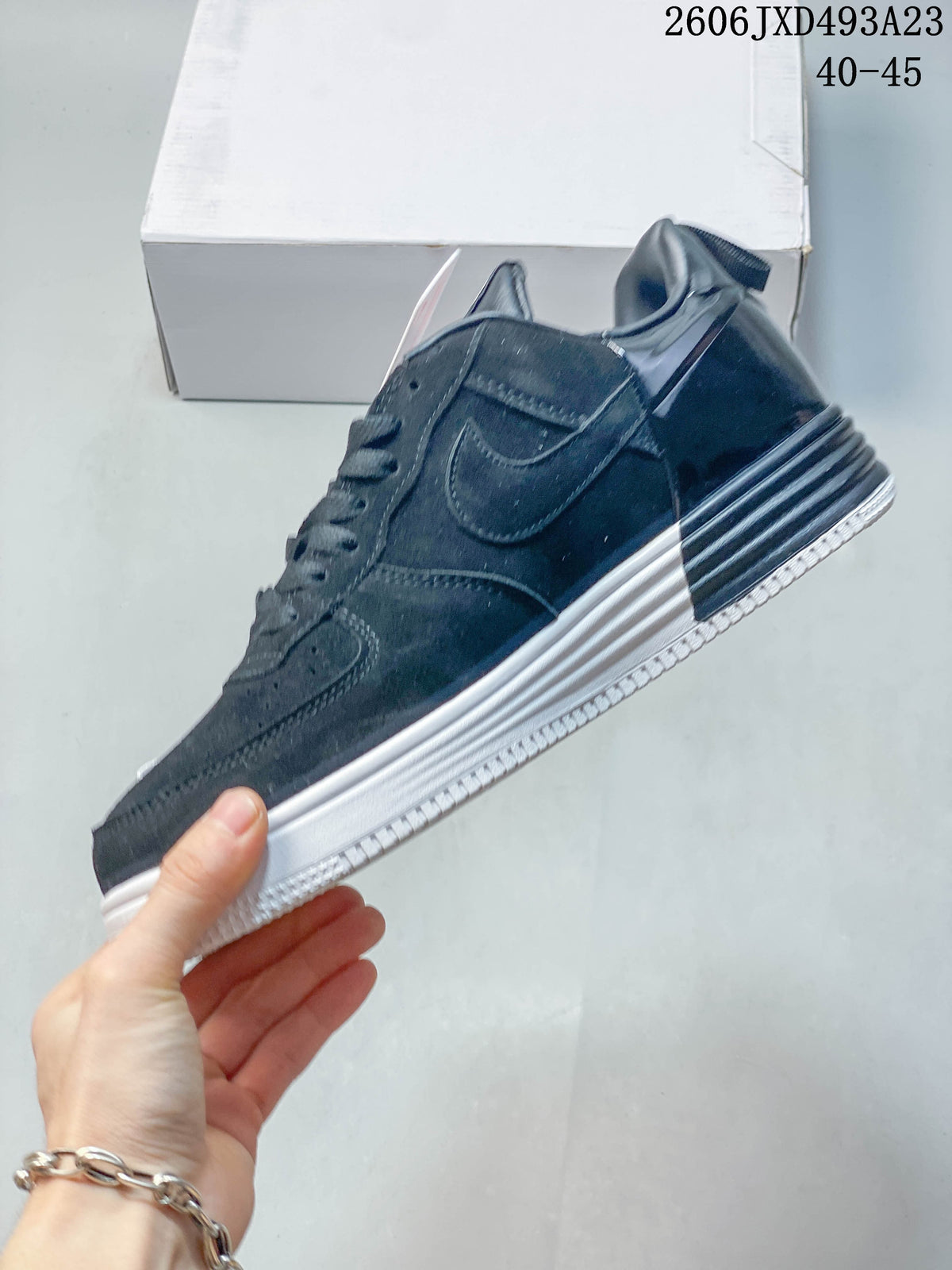 Side profile of the dark low-top sneaker with white layered sole.