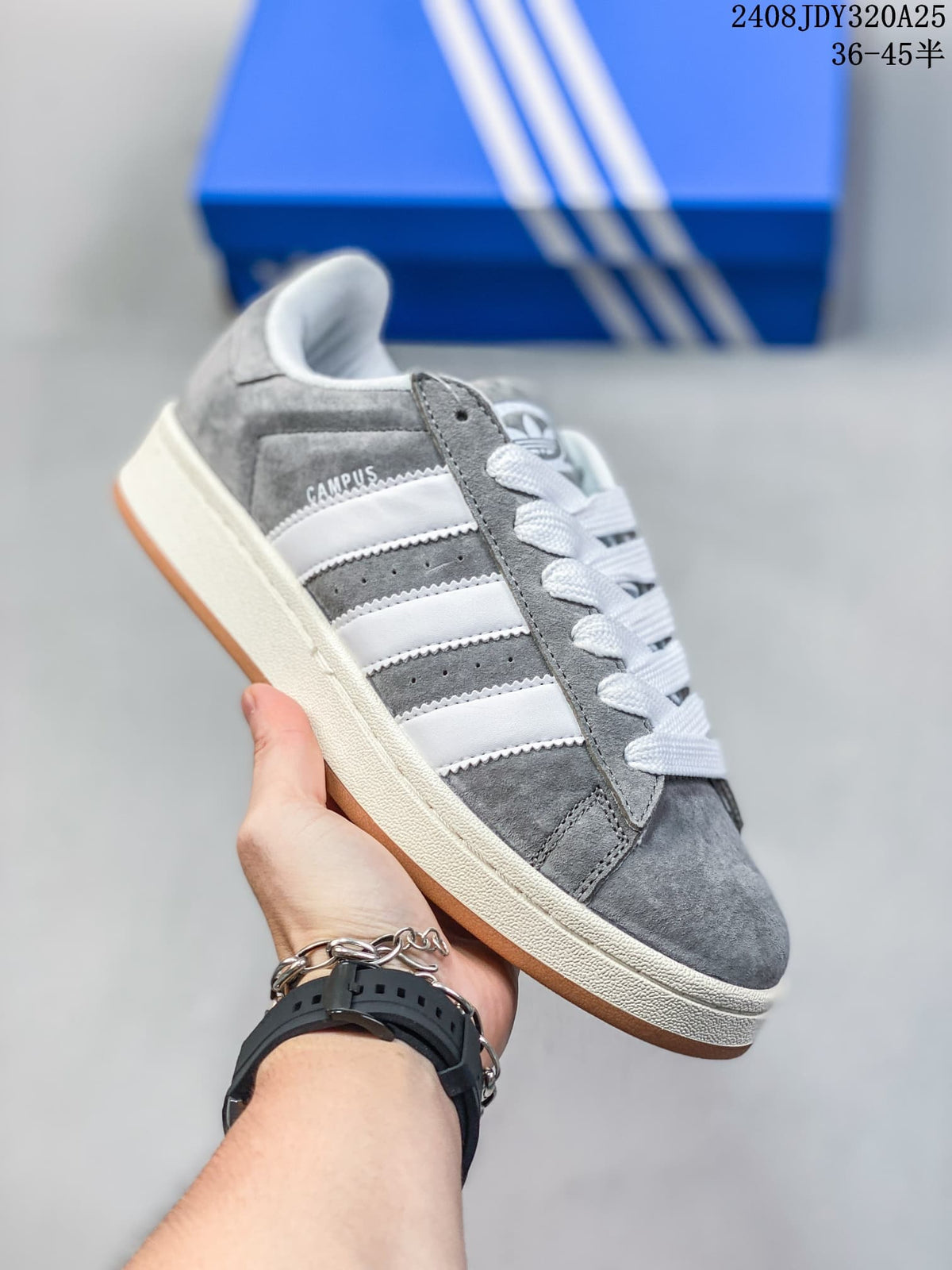 Angled side view of the grey sneaker with white stripes and a gum-colored outsole.