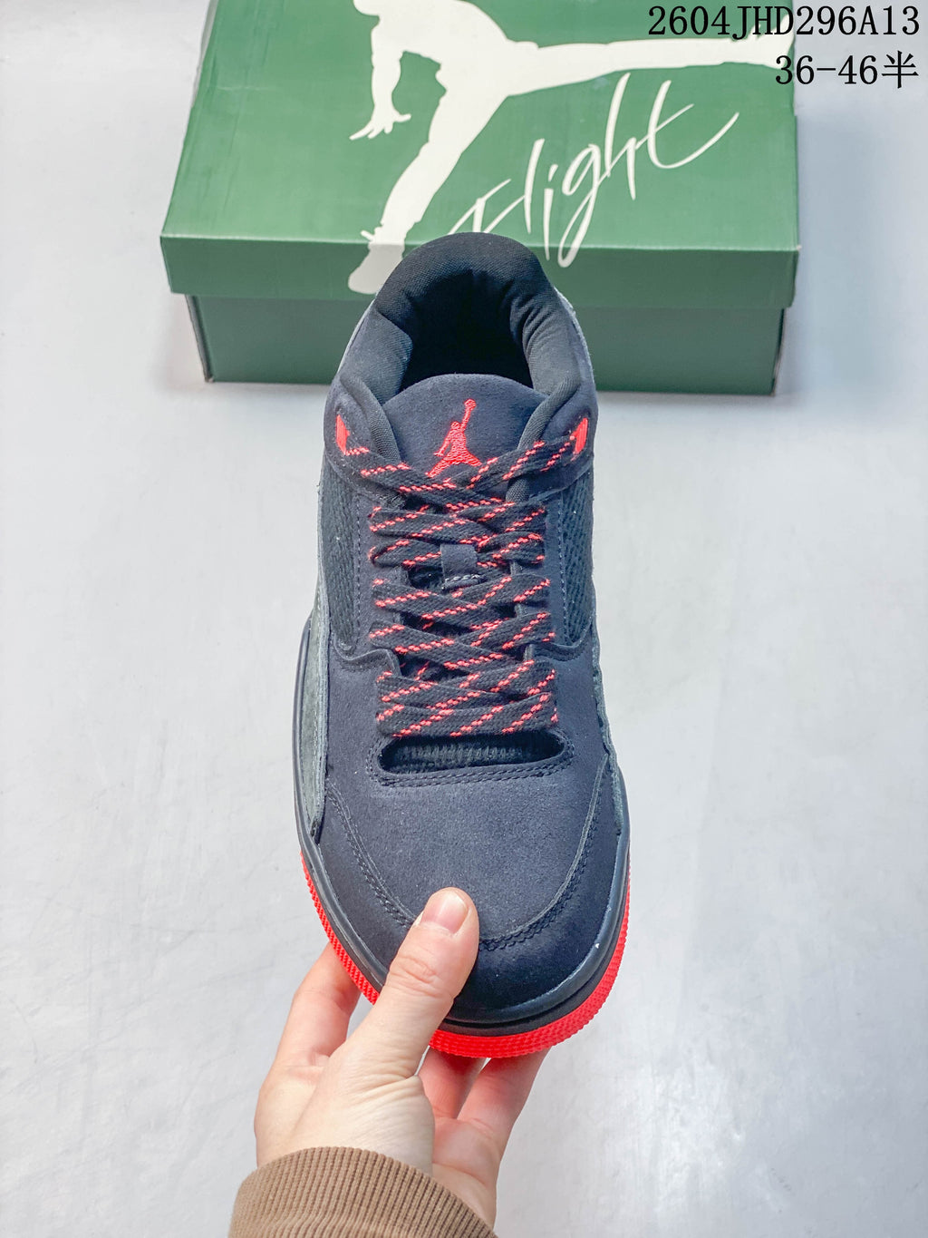 Front view of a navy sneaker with contrast laces, mesh panels, and red accents.