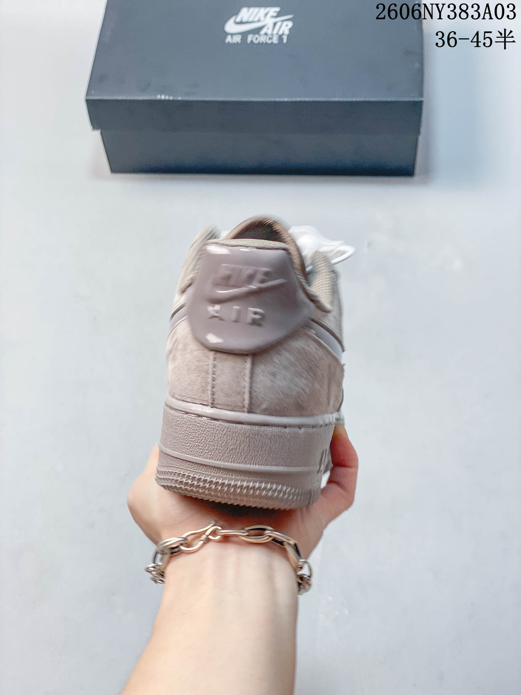 Rear view of a taupe low-top sneaker with heel branding