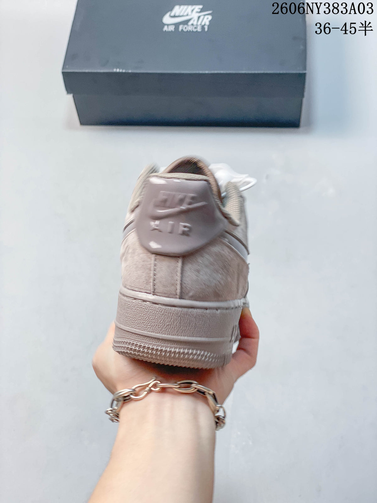 Rear view of a taupe low-top sneaker with heel branding